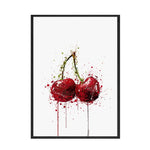 Cette image montre deux cerises rouges éclaboussées de gouttes rouges et vertes, créant une composition artistique abstraite et dynamique.