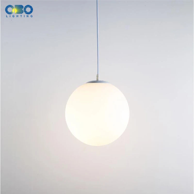 Lampe suspension verre blanc éclairée dans un intérieur moderne