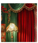 Rideaux élégants en velours rouge et vert avec détails dorés, idéal pour une décoration intérieure sophistiquée. Décoratif et luxueux, ce rideau ajoute une touche de chic classique à tout salon ou salle à manger. Parfait pour créer une ambiance chaleureuse et accueillante. Fixé près d'une lampe victorieuse et de meubles richement ornés, ce rideau est un choix parfait pour une décoration intérieure vintage raffinée.