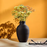 Vase rouge design épuré avec fleurs séchées en décoration intérieure