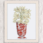 Un bouquet de lis gracieux dans un vase décoré de motifs rouges fleuris.