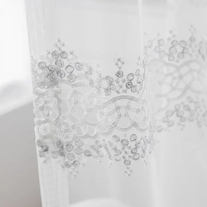 Rideau voilage blanc brodé dans un salon moderne