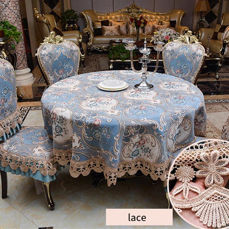 La table est recouverte d'une nappe bleue ornée de motifs floraux délicats, bordée d'une dentelle beige élégante, créant une ambiance raffinée et chaleureuse dans cette pièce somptueuse.