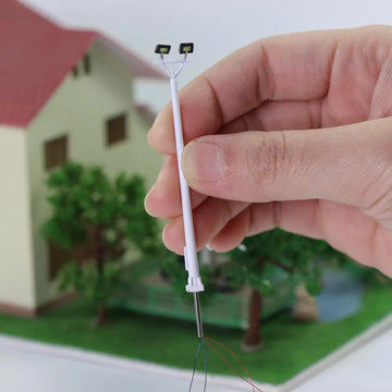 poteau lumineux miniature led blanc moderne deux projecteurs câbles noirs rouges urbain