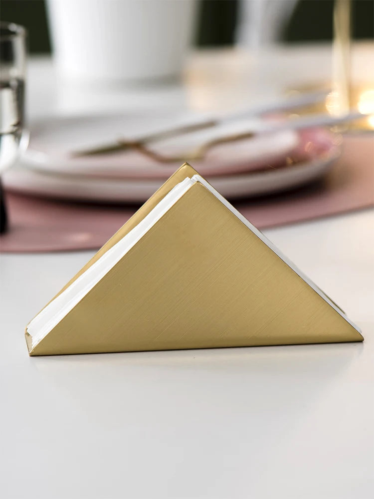 Porte-serviettes or sur table de mariage avec nappe blanche