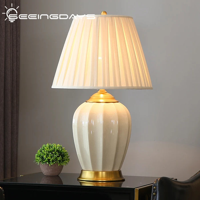 Lampe de chevet en céramique ivoire avec abat-jour vert sur table de nuit