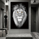 Cette image en noir et blanc présente un gros plan impressionnant du visage d'un lion majestueux, avec des yeux vifs et une crinière épaisse.