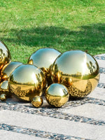 Collection de boules décoratives de différentes tailles et couleurs dans un jardin