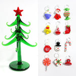 Composition festive avec sapin en verre et ornements sur table de salon