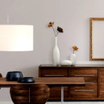 Un intérieur élégant avec des meubles en bois foncé, des vases blancs et des fleurs séchées apportant une touche de décoration.