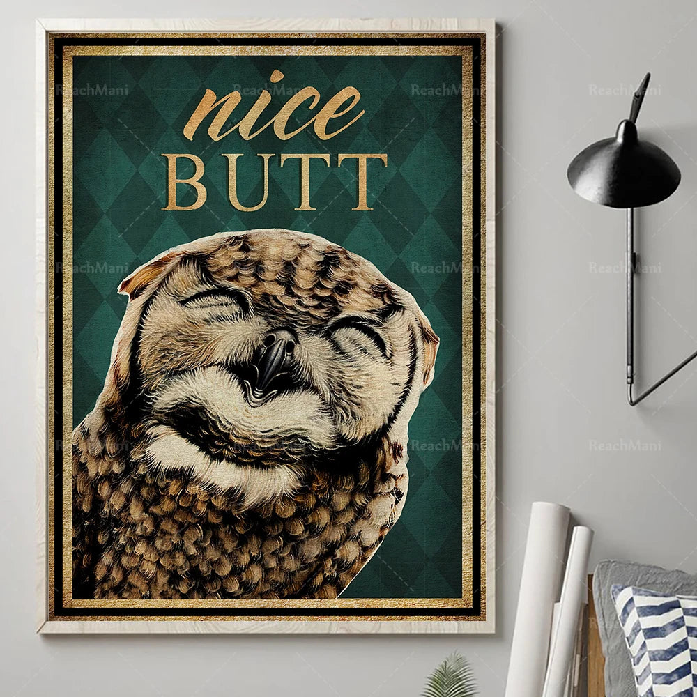 Un gros plan sur le visage d'un oiseau aux plumes dorées et brunes, avec le texte "Nice Butt" en lettrage doré sur un fond vert foncé dans un cadre décoratif.