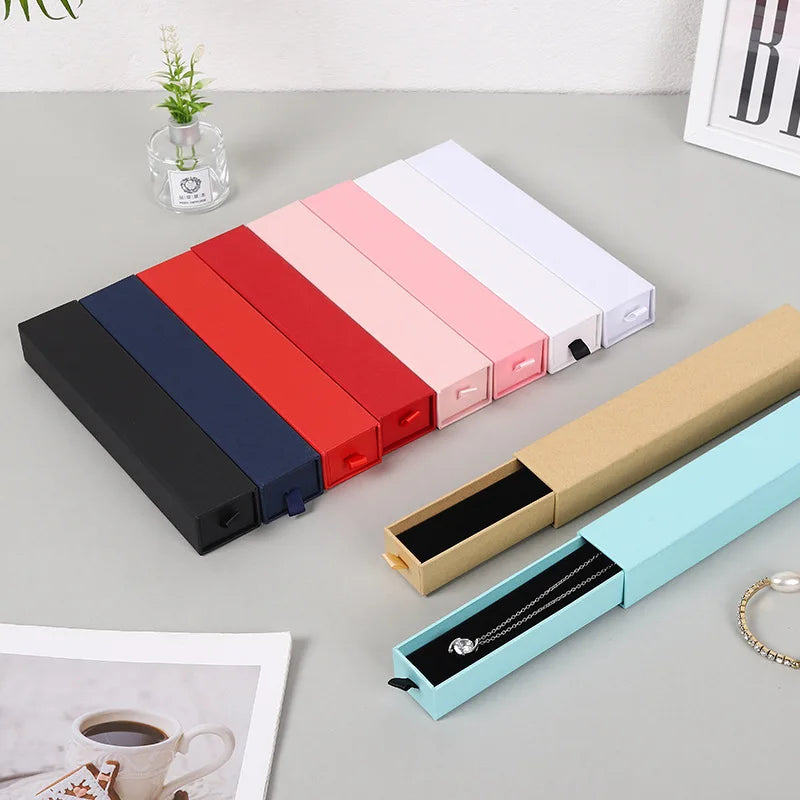 Boîte à bijoux noire avec colliers et bagues à l'intérieur