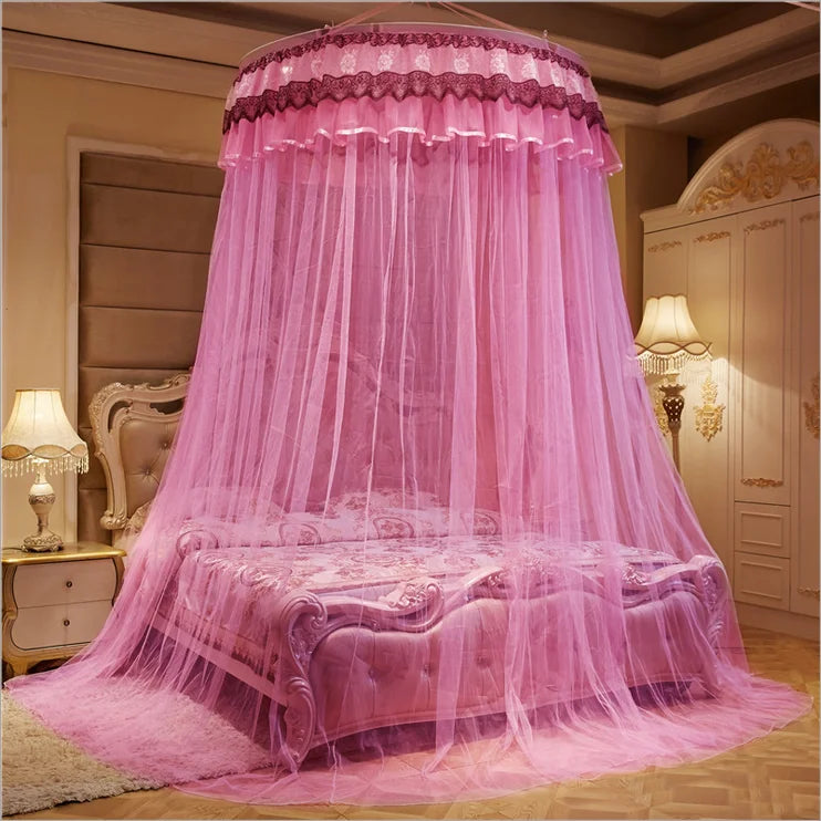 Magnifique ciel de lit rose décoratif avec du tulle et des ornements élégants, installé sur un lit douillet et luxueux dans une chambre meublée avec goût.