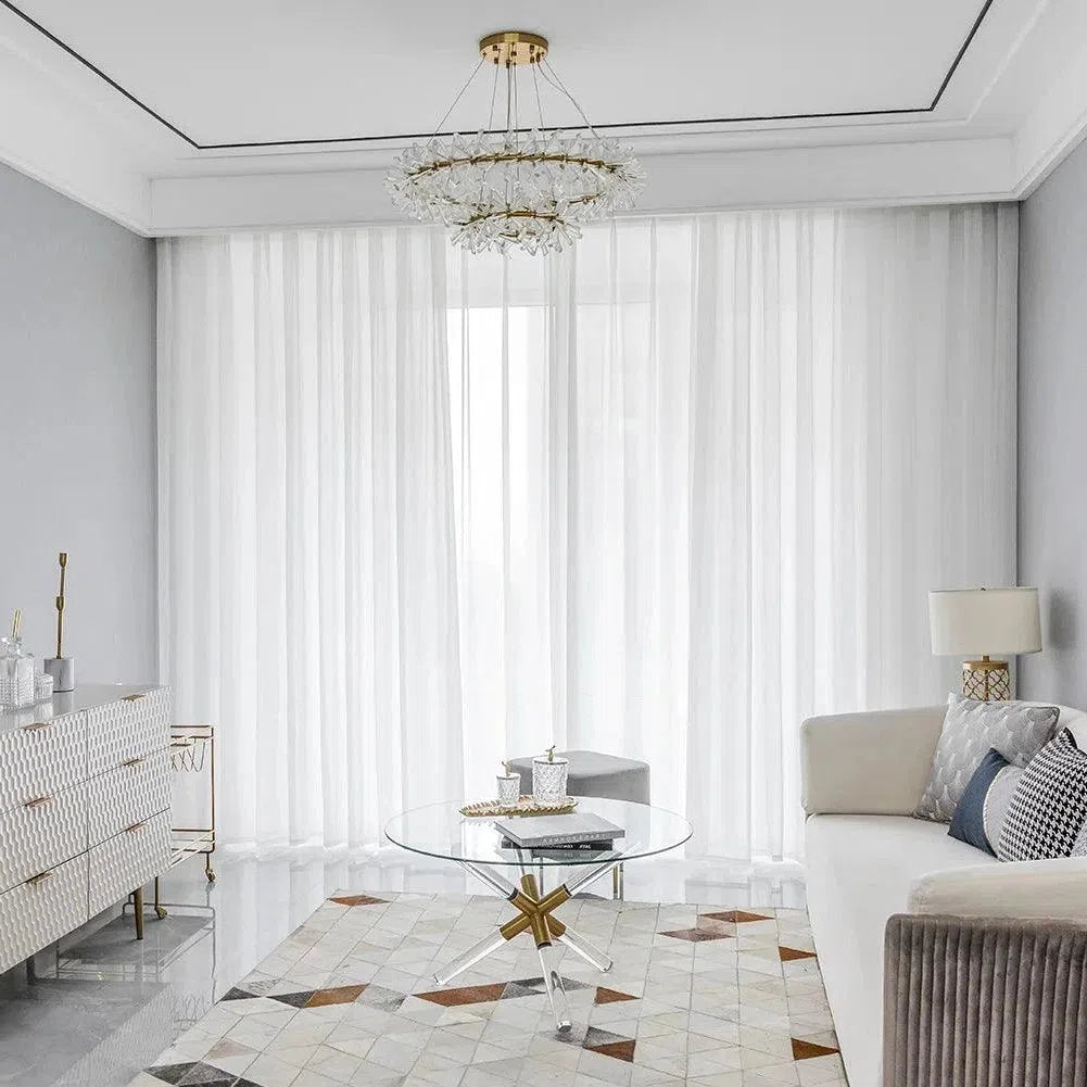 Salon moderne et élégant avec canapé confortable, table basse design, tapis géométrique et lustre raffiné. Idéal pour créer une atmosphère lumineuse et accueillante. Parfait pour la décoration intérieure contemporaine.