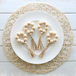 Détail des perles en bois et pompons en jute des anneaux de serviette