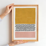 Composition géométrique abstraite aux tons ocre, rose et noirs sur un fond blanc, encadrée.