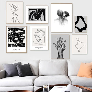Galerie murale moderne avec une collection d'estampes et d'illustrations en noir et blanc, créant une ambiance artistique et épurée dans un intérieur.