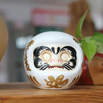 statuette japonaise daruma rouge blanche visage sourire motifs dorés traditionnels feng shui ornement chance