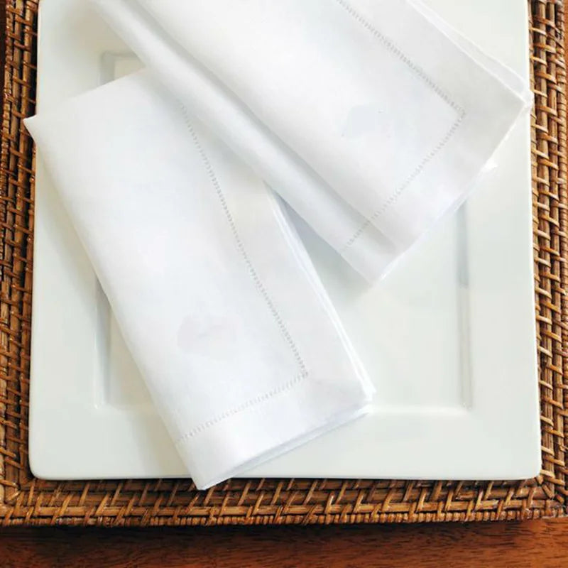Un plateau en osier recouvert de serviettes blanches, une image simple et apaisante.