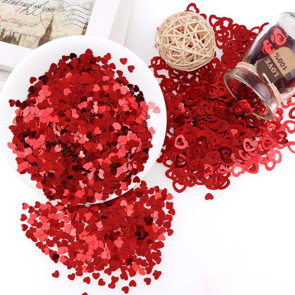 Détail des confettis étoiles et cœurs en PVC rouge