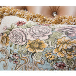 Somptueux tapis de fleurs aux couleurs chatoyantes, avec des motifs de roses, de pivoines et de chrysanthèmes sur un fond bleu et doré.