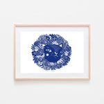 Un chat bleu entouré de fleurs élégantes dans un cadre en bois.