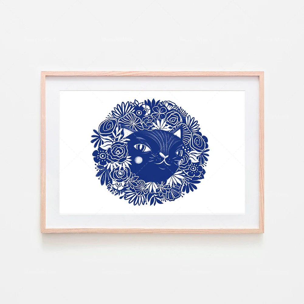 Un chat bleu entouré de fleurs élégantes dans un cadre en bois.