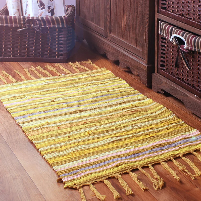 Tapis rayé jaune et blanc sur un sol en bois rustique avec des paniers en osier dans une atmosphère chaleureuse.