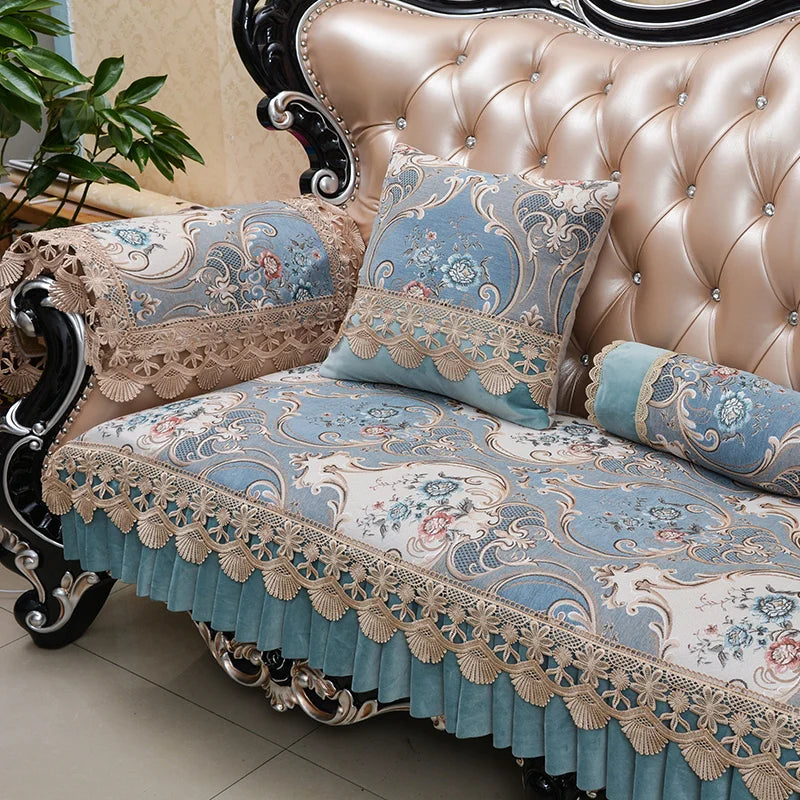 Un élégant canapé en cuir capitonné de couleur beige, orné de motifs floraux bleutés et de dentelle dorée, créant une atmosphère de luxe et de raffinement.