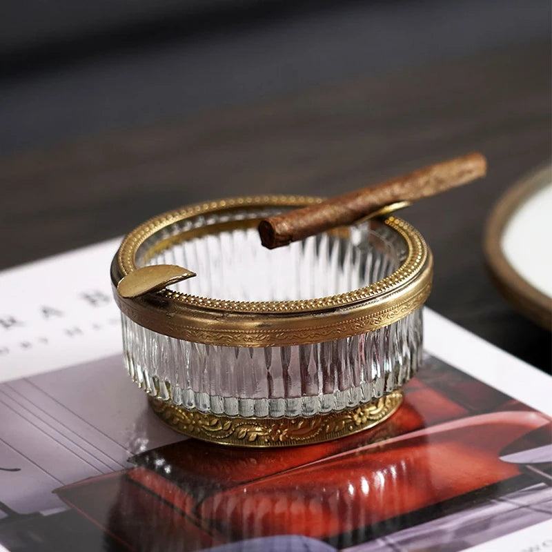 Peigne à cheveux décoratif en métal doré avec des dents en plastique transparentes, posé sur des magazines.