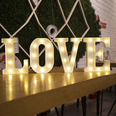 Lettre lumineuse LED blanche sur table de chevet dans une chambre