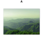 Paysage montagneux aux doux dégradés de vert, avec des collines boisées s'élevant à l'horizon sous un ciel nuageux.