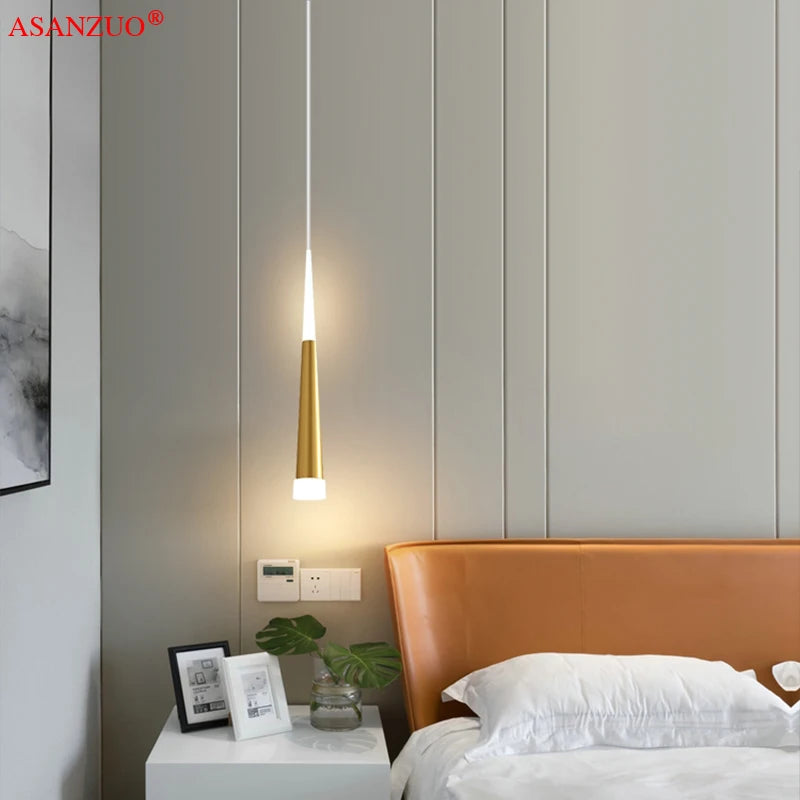 Lampe suspendue installée au-dessus d'une table de chevet en bois