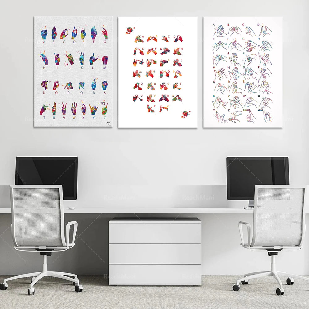 Cette image montre trois affiches artistiques représentant des signes manuels et des gestes expressifs en couleurs vives, qui sont accrochées au mur au-dessus d'un bureau de travail moderne avec deux chaises de bureau blanches.