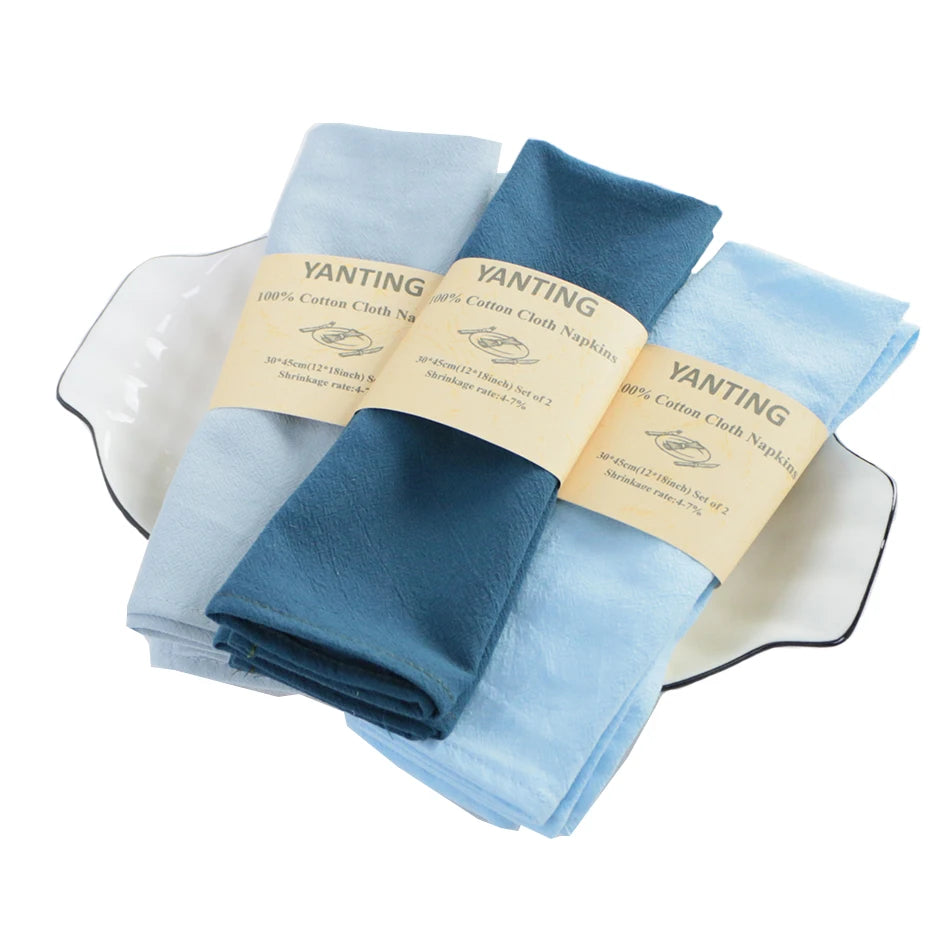 Ces serviettes en coton 100% de la marque Yanting sont disponibles en couleurs bleu clair et bleu foncé, avec des étiquettes jaunes.