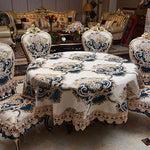 Élégante table à manger et canapés dans un style victorien avec des motifs floraux et dorés, reflétant un environnement luxueux et raffiné.