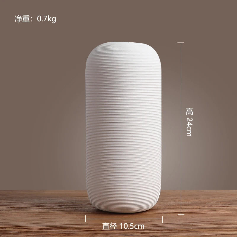 Vase décoratif cylindrique blanc en céramique avec un motif à rayures horizontales, mesurant 24 cm de hauteur et 10,5 cm de diamètre, avec un poids de 0,7 kg.