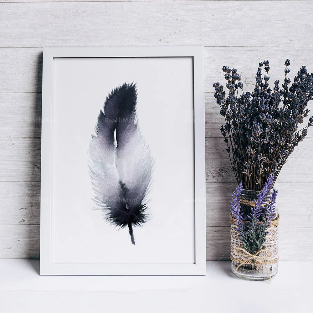 Une délicate plume en noir et blanc encadrée sur un mur en bois, avec un bouquet de lavande dans un vase vintage orné de dentelle.