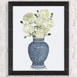 Un magnifique bouquet de fleurs blanches épanouies dans un vase en céramique bleu et blanc orné de motifs délicats.