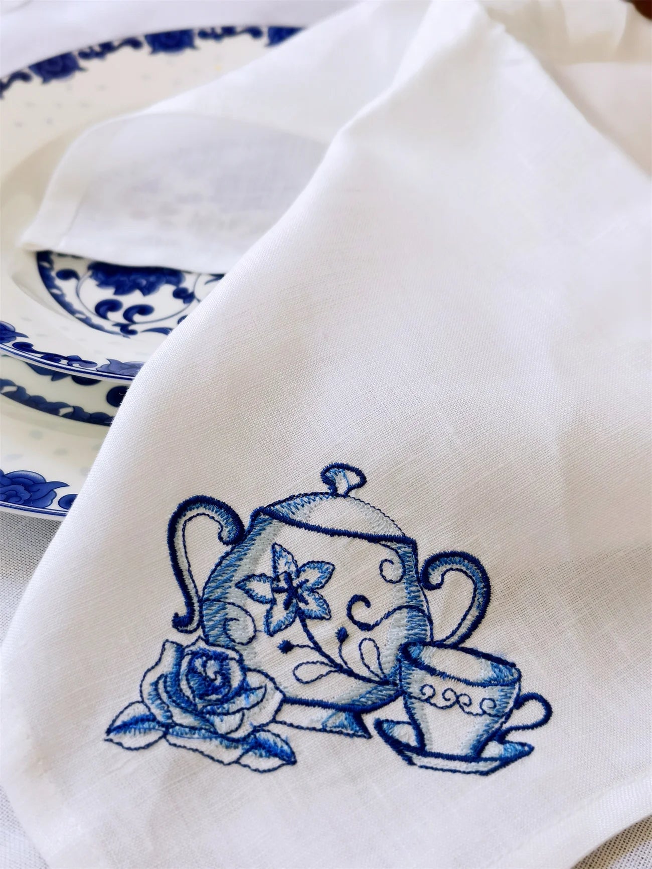 Détail broderie théière sur serviette lin