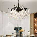lustre moderne cristal K9 doré noir ampoules LED branches stylisées transparentes salon mariage
