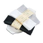 Cette image montre plusieurs paquets de lingettes de toilette blanches et noires, avec des étiquettes imprimées indiquant qu'il s'agit de lingettes Yanting.