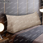 Housse coussin triangle gris utilisé comme tête de lit décorative