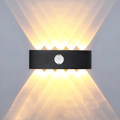 Applique murale extérieure LED noire avec détecteur de mouvement sur un mur de jardin