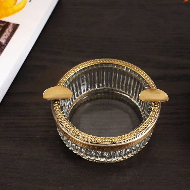 Un bol en verre transparent avec des détails dorés, posé sur une surface en bois sombre.