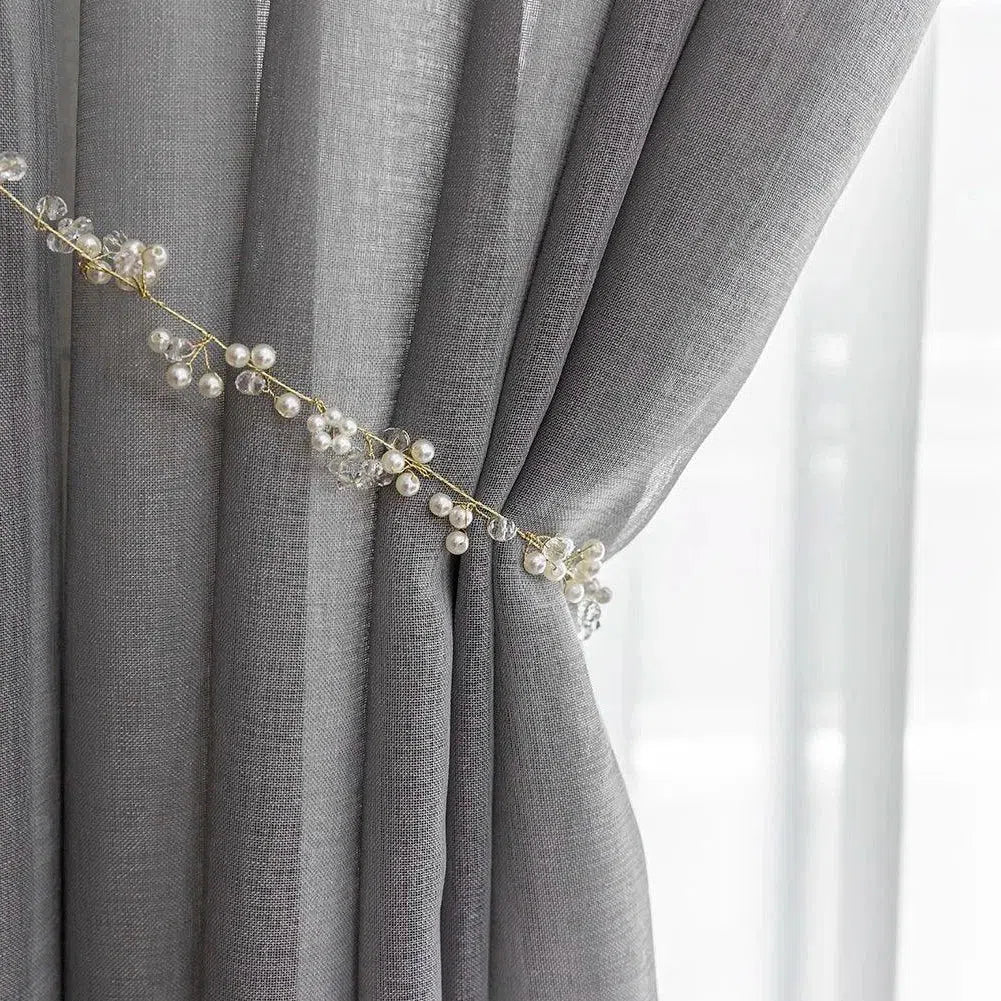 Rideau élégant en couleur grise avec embrasse décorative de perles et cristaux, parfait pour ajouter une touche raffinée à la décoration intérieure. Accessoire idéal pour personnaliser un salon ou une chambre, ce rideau apporte une ambiance chic et moderne. Adapté pour filtrer la lumière et créer une atmosphère apaisante.