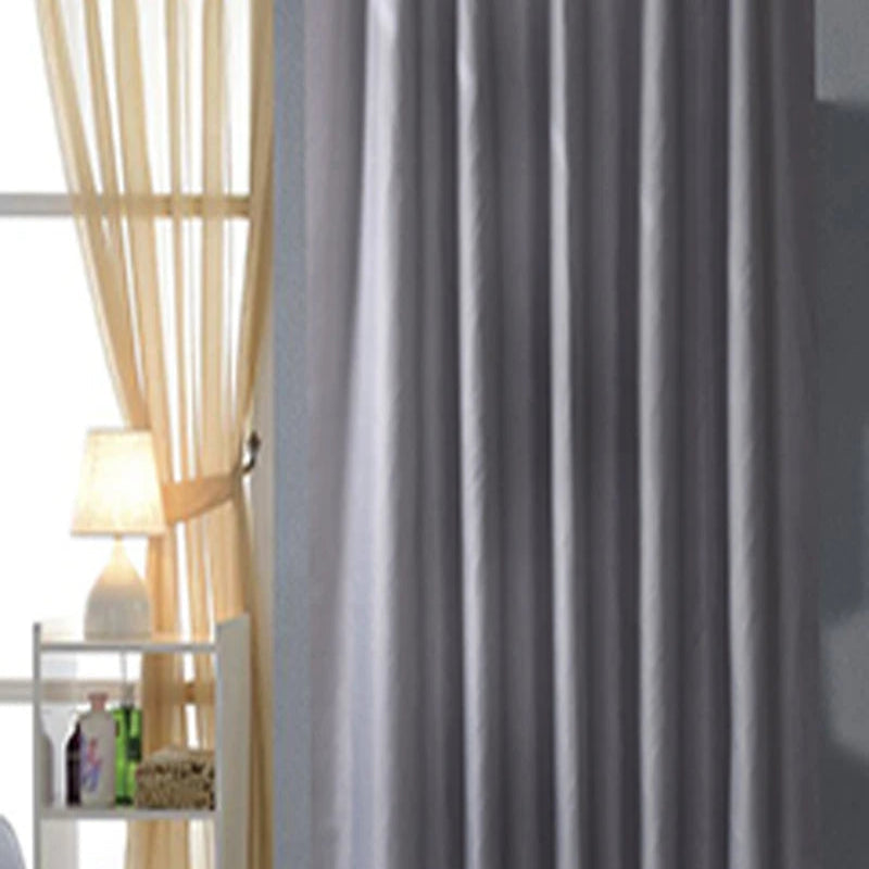 Textile de qualité supérieure, rideau de douche gris et argent avec des oeillets, utilisé comme couverture pour se laver en toute tranquillité. Les détails visibles incluent la texture luxueuse du polyester et la couleur subtile de l'argent. En contexte, le rideau complète parfaitement un ensemble de linge de maison assorti.