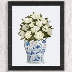 Cette image représente un bouquet de fleurs blanches magnifiques dans un vase orné de motifs floraux bleus.