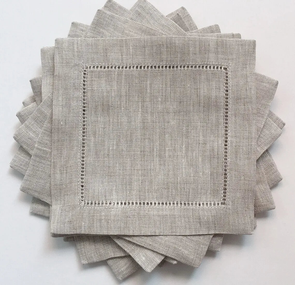 Serviettes de table en lin gris clair avec bordure à points, parfaites pour une table élégante et raffinée.