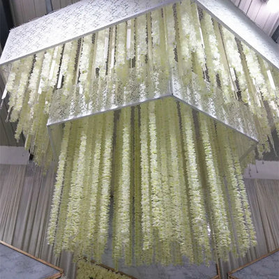 Guirlande de fleurs artificielles en soie et rotin orchidée suspendue sur un mur blanc